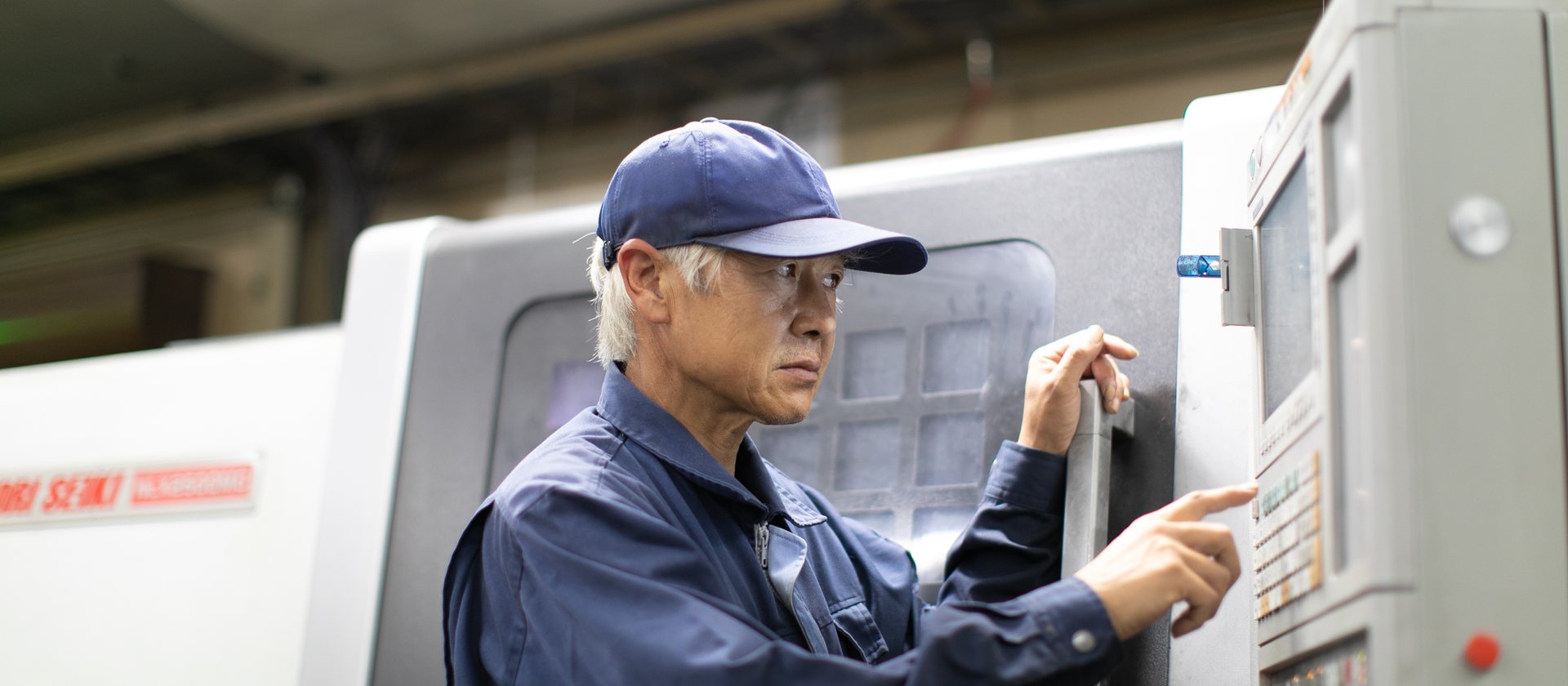 工場でマシニングセンタを操作する様子